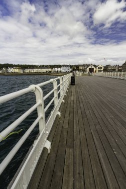 BeaUMARIS, WALES 12 HAZİRAN 2022 Geniş rıhtım açısı ve ön planda el ray ve RNLI filika istasyonu, Beaumaris, Birleşik Krallık ve deniz manzaralı evler, portre