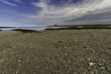 Cemlyn Körfezi 'nin batı ucunda Anglesey, Galler' in kuzey kıyısında. Duvar, çakıl taşı plaj ve deniz, mavi gökyüzü, manzara, geniş açı.