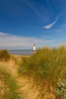 Ayr Noktası veya Talacre Deniz Feneri, Galler, İngiltere 'nin kuzey sahilinde geniş açı, önplanda kum tepeleri ve yol, tepede kopyalanmış uzay, gökyüzünde yer alır.