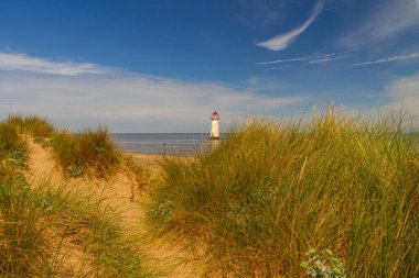 The Point of Ayr or Talacre Lighthouse is on the north coast of Wales, UK, wide angle, Sand dunes and path in foreground, copyspace at top, sky clipart