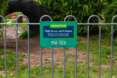 TAUNTON, ENGLAND JULY 30 2021: Sign by weir for the Samaritans with contact telephone number, landscape. clipart