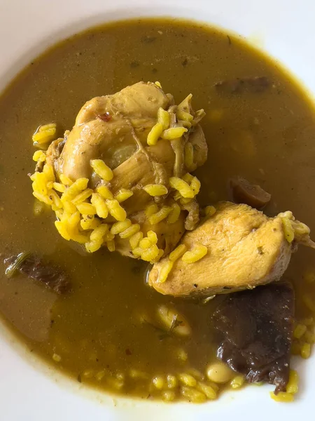 Typical food in Ibiza, Spain. A comforting bowl of Arroz de MAtranza, a soup or stew of rice ad different meats, cooked with broth, saffron and spices. Traditional festive restaurant dish.