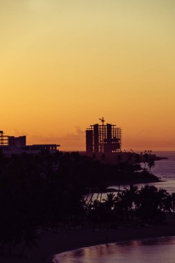 Turistik bir bölgede inşa edilen bir binanın yapısı veya iskeleti. Güneşin doğuşu ya da günbatımı turuncu gökyüzü ile güzel siluet kontrast.