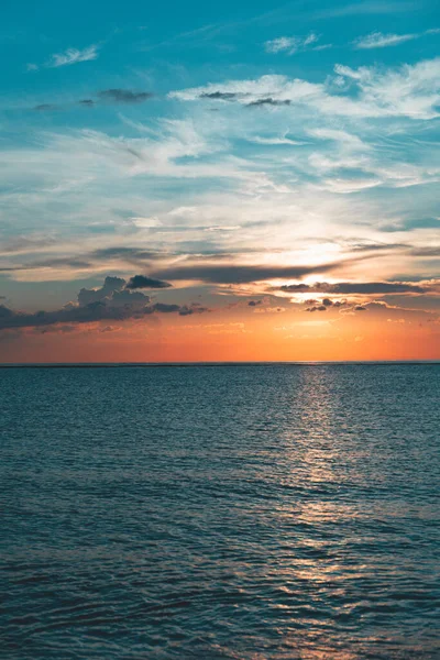 stock image Scenic sunset in the Playa de la Cueva Beach, Cabo Rojo, Pedernales, Dominican Republic. Vibrant colors, sun above water falling in the sea. Romantic vacation atmosphere.