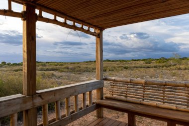 Eco Lodge ya da Eko Resort tipik bungalow verandası ya da verandası, hepsi ahşap ve hasırdan yapılmış. Issız arazi, dramatik gökyüzü ile güzel tezat. Kuş uçmaz kervan geçmez bir yerde.