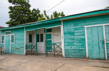 Pedernales, Dominik Cumhuriyeti, 22 Ağustos 2022. Geçen yüzyılın tipik ahşap Dominik evleri, ahşaptan yapılmış ve parlak renklerle boyanmış. Parlak asit yeşili boyalı ev ya da bungalov. 