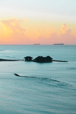Juan Dolio, Dominik Cumhuriyeti, 17 Ağustos 2022. Huzurlu Karayip denizindeki bir dizi bungalovun üzerinden geniş açılı çekim. Tatlı gün doğumu ya da gün batımı.
