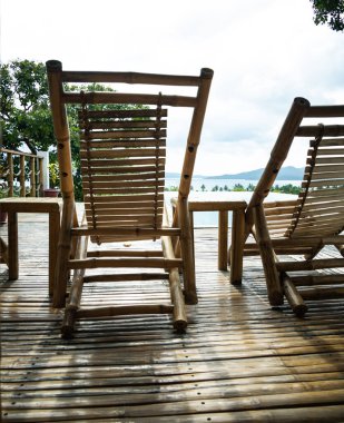 Asya turistik merkezindeki lüks bir tatil beldesinin avlusundaki iki bambu güneşliğin altından yakın çekim. Tatil havası, tropikal atmosfer.