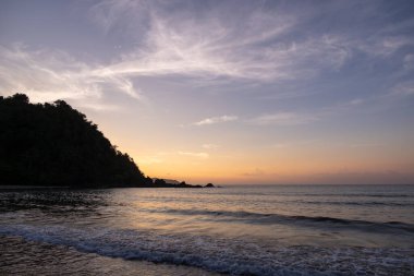 Filipinler 'deki Duli Sahili' nde yoğun turuncu ve pembe günbatımı. Güneş batıyor, gökyüzü yanıyor, altın saat..