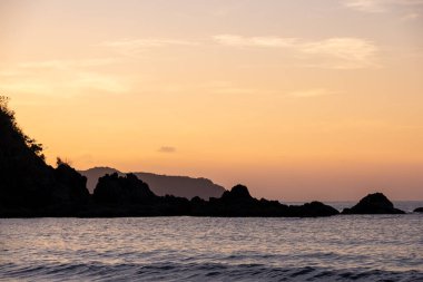 Filipinler 'deki Duli Sahili' nde yoğun turuncu ve pembe günbatımı. Güneş batıyor, gökyüzü yanıyor, altın saat..