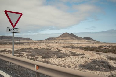 Fuerteventura 'nın merkezindeki ada volkanlarının garip, düşmanca ama büyüleyici manzarası. Adanın kuzey tarafında. Yol tabelasıyla.