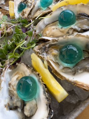 Makro, bir tepsi taze istiridyeye yakın. Moleküler mutfak köpüğü ile dekore edilmiş. Pahalı restoran aperatifleri.