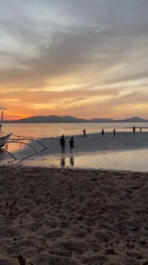 Filipinler 'de güzel bir gün batımında bir grup çocuğun plajda oynayıp koştuğunu gösteren dikey videolar. Kaygısız anlar, neşeyi paylaşmak, hatıralar yaratmak, arkadaşlık kavramı.. 