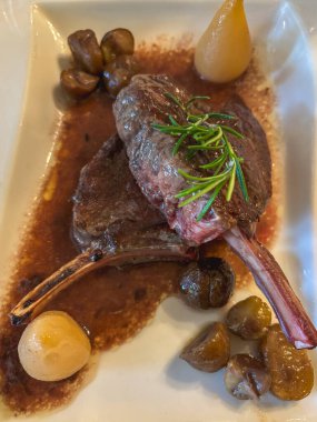 İki sulu restoran geyiğinin ya da kaynamış armut ve Sforzato şarabı ile servis edilen geyik pirzolasının yakından çekimi..