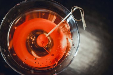 Milano, İtalya 'da bir aperatif barın tezgahında Manhattan Cocktail' in üstünden yakın çekim. Camın kenarındaki kırmızı kirazlı çubukta. Aperatif, içki..