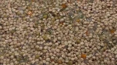 İtalyan geleneksel Noel ve şenlikli yemek: yumuşak fritto ile mercimek, tavada yavaşça fokurduyor. Gerçek ev yemekleri. Mercimek hala çiğ. Vejetaryen ya da vejetaryen. Yatay video. 