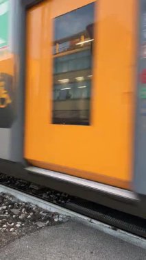 Bellaria Igea Marina, İtalya, 2 Haziran 2025 - İtalyan Ferrovie Dello Stato treni popüler bir turistik merkezin merkezindeki tren geçidinde geçiyor. Dikey video.