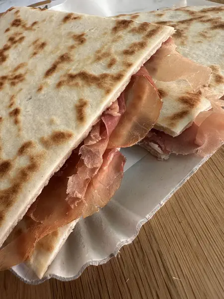 Lezzetli bir piadina romagnola yakın çekim İtalyan yassı ekmeği, jambonlu. Riviera Romagnola bölgesinden leziz bir lezzet. Atıştırmalık, yemek, sokak yemeği.