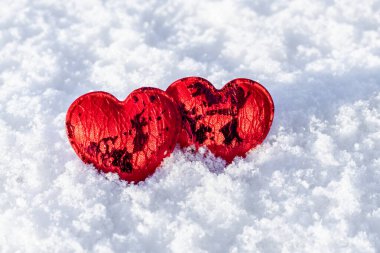 Beyaz karlı arka planda iki kırmızı kalp. Yakın plan. Sevgililer Günü konsepti. Sevgililer Günü
