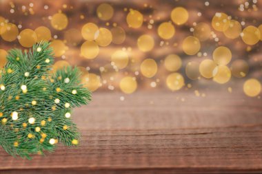 Noel ağacı dalları ve odağını kaybetmiş parlak ışık saçan şenlikli ahşap arka plan. Noel ya da Yeni Yıl için mükemmel.