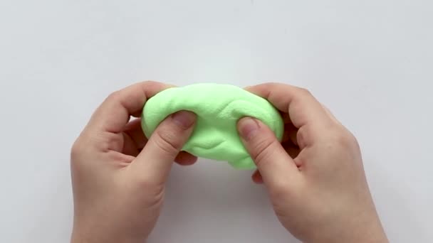 那孩子用双手雕刻绿色的塑料 — 图库视频影像