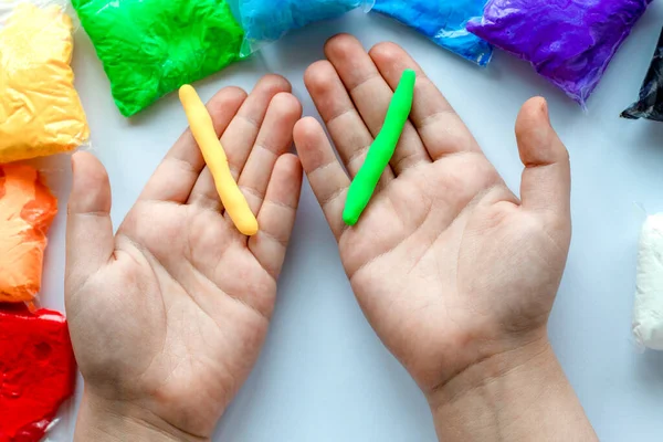 Criança Segura Suas Mãos Plasticina Verde Amarela Enrolada Flagelo — Fotografia de Stock