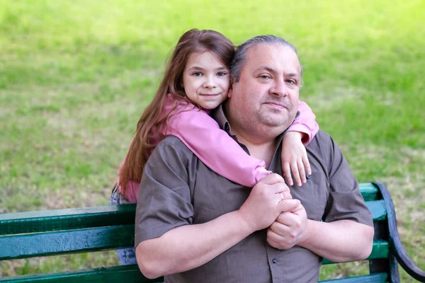 stock image Daughter lovingly hugs her father in the park. Fathers Day. Close-up. Copyspace