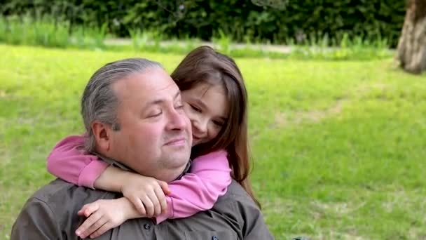 一个小女孩在公园里亲切地拥抱着她的父亲 父女俩幸福的概念父亲节 慢动作视频 — 图库视频影像