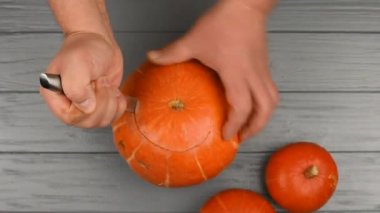 Bir balkabağını bıçakla kesen insan elleri Jack-o-feneri oymak için.
