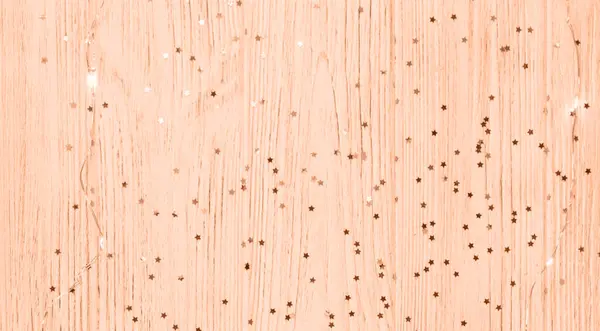Stars on a wooden peach background. color of the year 2024.