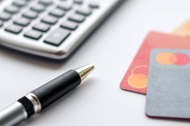 Kalem, kredi kartı ve hesap makinesine yakın çekim.