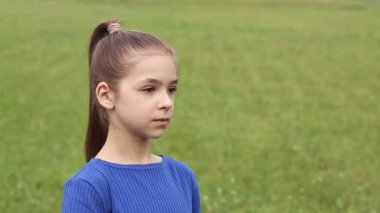 Kız sıcak ve güneşli bir günde susuzluğunu giderir ve su içer. Sağlıklı bir yaşam tarzı. Avrupalı görünümlü bir kız doğadaki bir şişeden su içiyor.