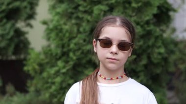 Modaya uygun güneş gözlüğü takan mutlu çocuk modeli..