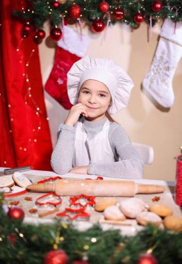 Şefin şapkasıyla gülümseyen bir kızın portresi..