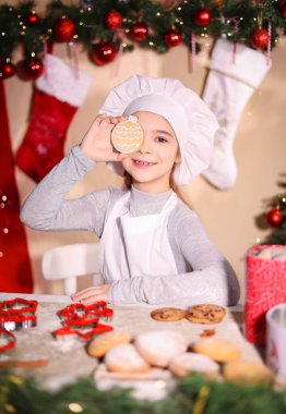 Neşeli kız gözlerini kapar Noel kurabiyesi şeklinde top şeklinde kurabiyelerle