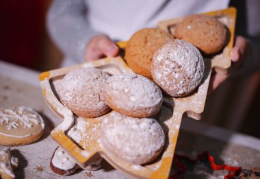 Ellerin kurabiyeleri Noel ağacı şeklinde bir tabakta tutuyor.