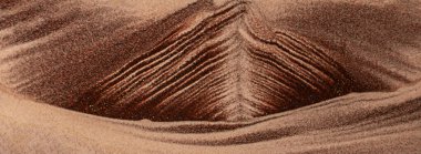 Kum oluşumlarının yakın çekimi büyüleyici doğal desenler ve dokular sergiliyor.