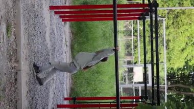 Fitness kızı spor salonunun yatay çubuğunda egzersiz yapıyor. Açık hava fitness.