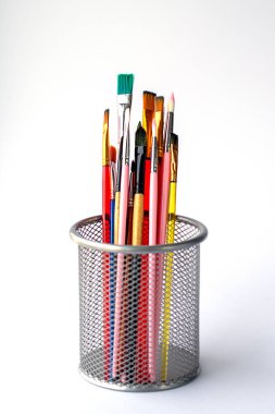 Metal bir kapta çeşitli boylarda boya fırçaları, beyaz renkte izole edilmiş.