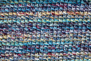 Çok renkli bir ipliğin yakın çekimi. Örgü desenleri. Karmaşık detaylar ve dokular sergiliyor.