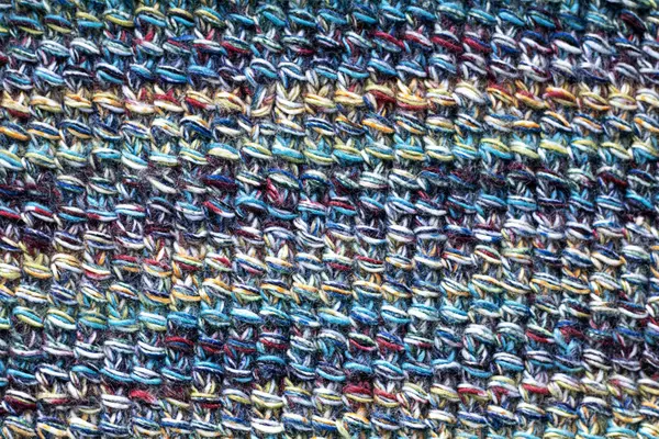 Çok renkli bir ipliğin yakın çekimi. Örgü desenleri. Karmaşık detaylar ve dokular sergiliyor.