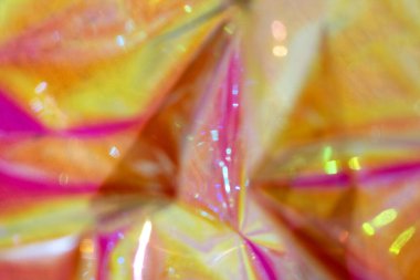 Canlı pembe, sarı ve turuncu desenler yanardöner ışık efektlerini anımsatıyor..