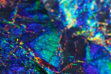 Renkli holografik dokular canlı gölgelerde yanardöner soyut bir yüzey gösteriyor.