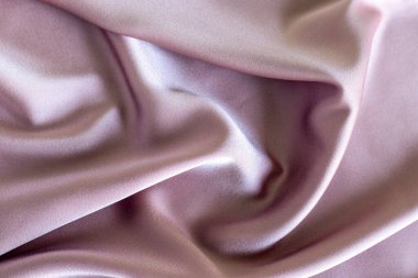 Hassas pembe tekstil, yumuşak kıvrımlar ve pürüzsüz doku, arka planlar için idealdir.