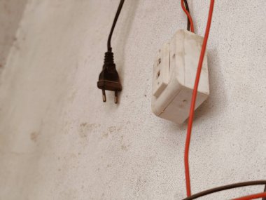 Arka planda kırmızı kablolar olan beyaz beton bir duvarı kapat