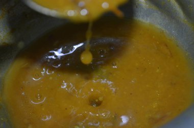 İçinde kaşık olan bir kase çorbanın kapağını kapat.