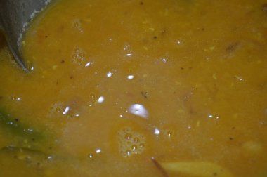 İçinde kaşık olan bir kase çorbanın kapağını kapat.