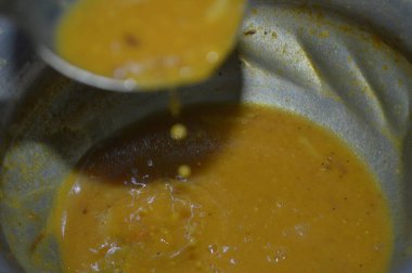 İçinde kaşık olan bir kase çorbanın kapağını kapat.