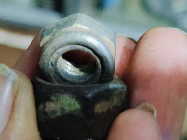 Metal ceviz tutan bir adamın yakın plan fotoğrafı.