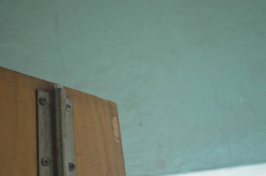 Kahverengi ahşap kapılı yeşil duvarın dikey görüntüsü.